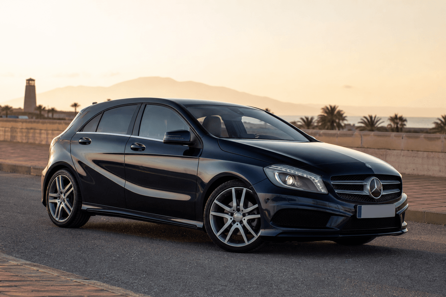 Mercedes-Benz Clase A W176 azul en carretera costera al atardecer